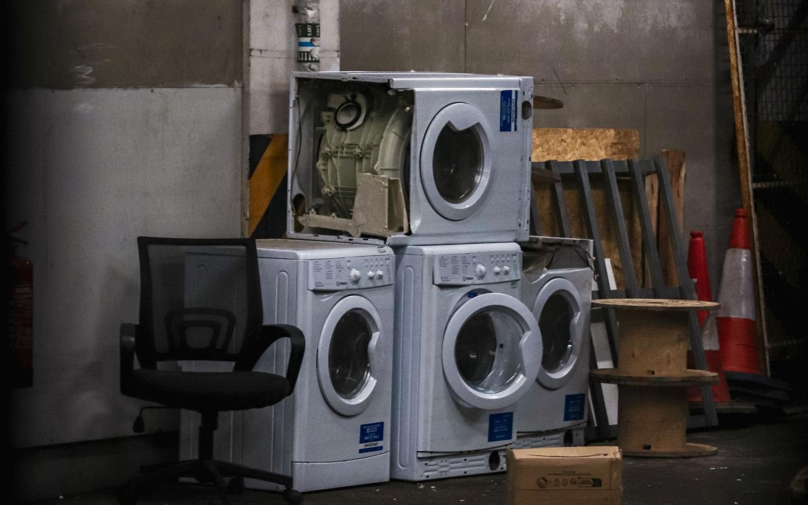 Discarded washing machines and an old office chair set out for bulky item pickup.